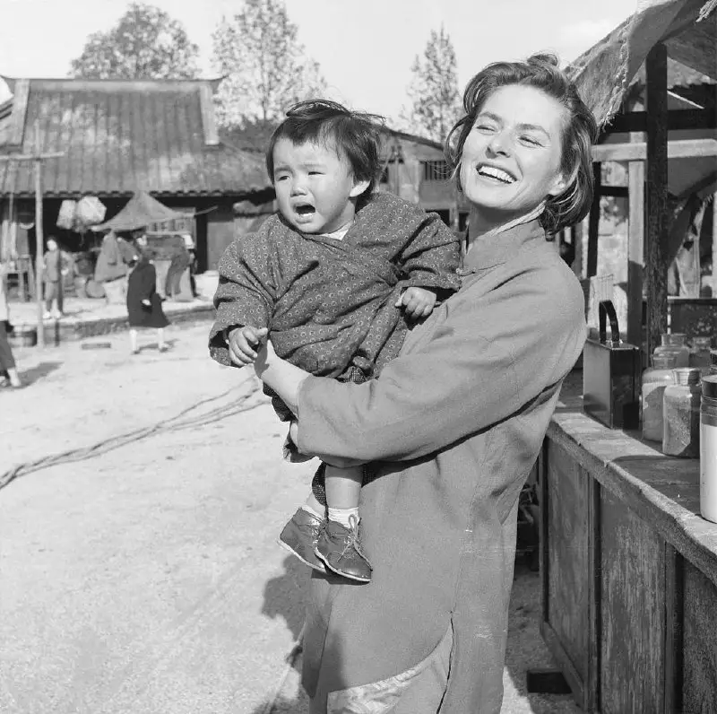 **Ingrid Bergman holding a toddler on …