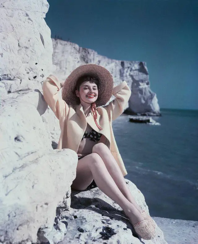 **Audrey Hepburn, sitting on a rock …