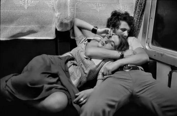 A couple sleeping on a train, …
