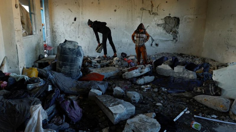 Palestinians inspect the damage in the …