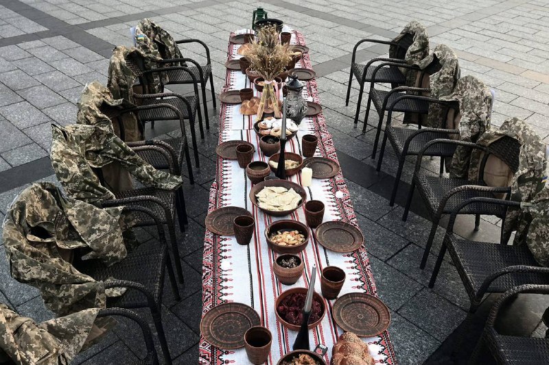 象征性的圣诞餐桌旁空椅子上摆放着士兵制服，这是为了提醒人们关注战俘和失踪的士兵。